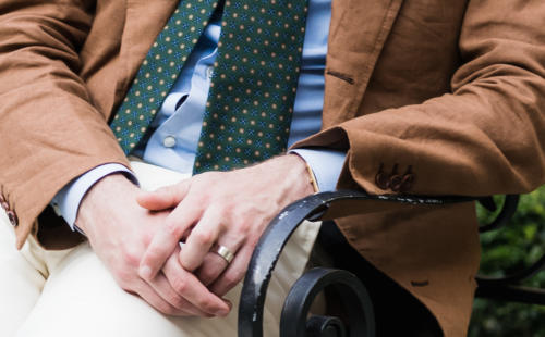 Tobacco linen suit and cream trousers close up