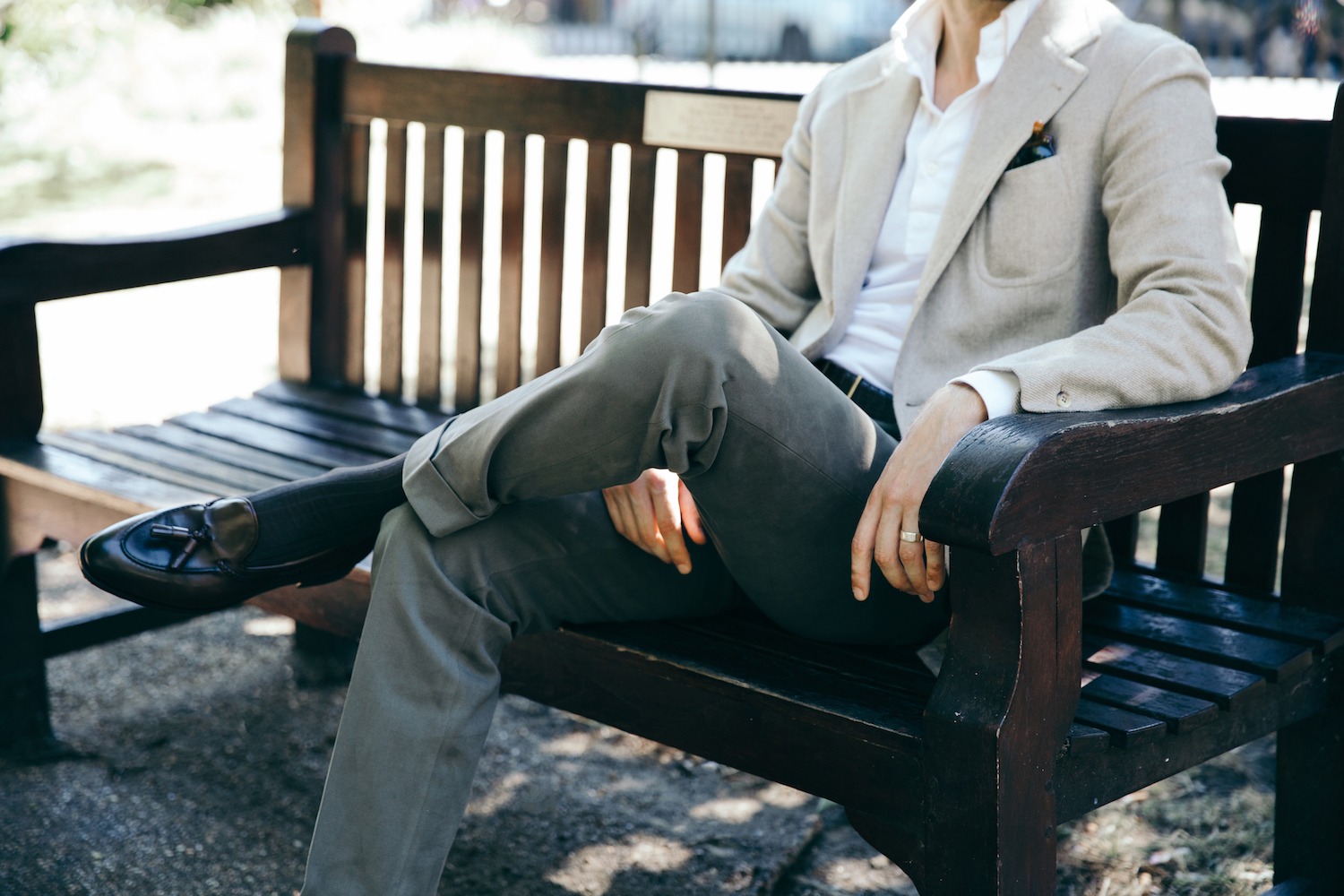 Premium Photo  Man in a white shirt and blue trousers is tying his shoes  sitting on a chair closeup